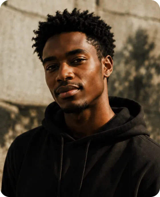 A creator in a black hoodie photographed outdoors in warm evening light